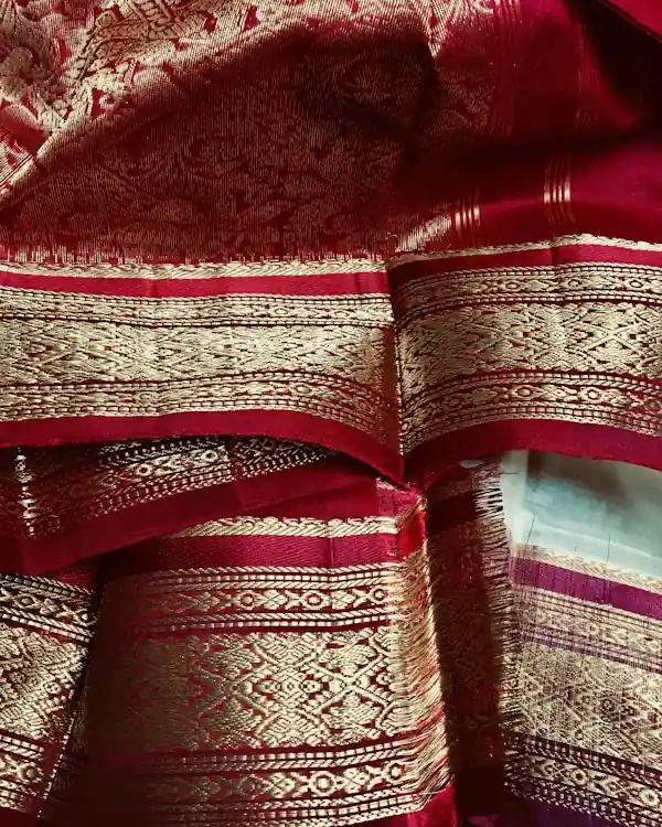 Close-up of a red Banarasi silk saree with gold zari brocade border