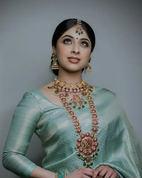 Woman wearing a light sea-green Chanderi saree with gold jewellery