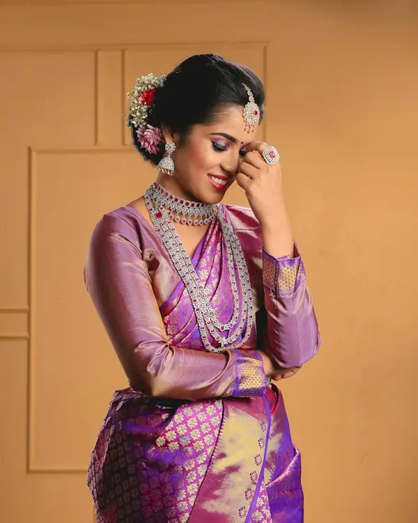 Woman wearing a purple and gold Kanjeevaram silk saree